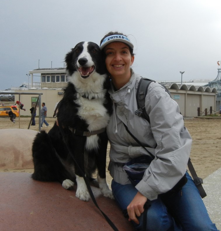 Irith smiling with black and white dog facing camera 